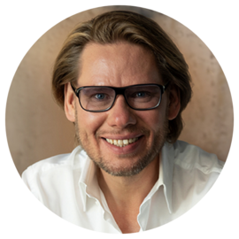 Porträt von Ralf Schuppan, leger gekleidet mit weißem Hemd und Brille. Er ist Geschäftsführer der Schuppan Management Solutions GmbH.